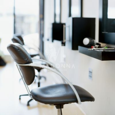Hair Salon A comfortable salon chair in a hair salon, with multiple mirrors enhancing the spacious and inviting atmosphere.