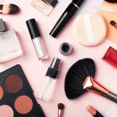 Makeup Appointment A collection of beauty products, including blush and mascara, set against a cheerful pink surface.